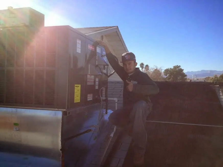 HVAC technician performing AC Tune-Up on a rooftop unit in Mount Sterling